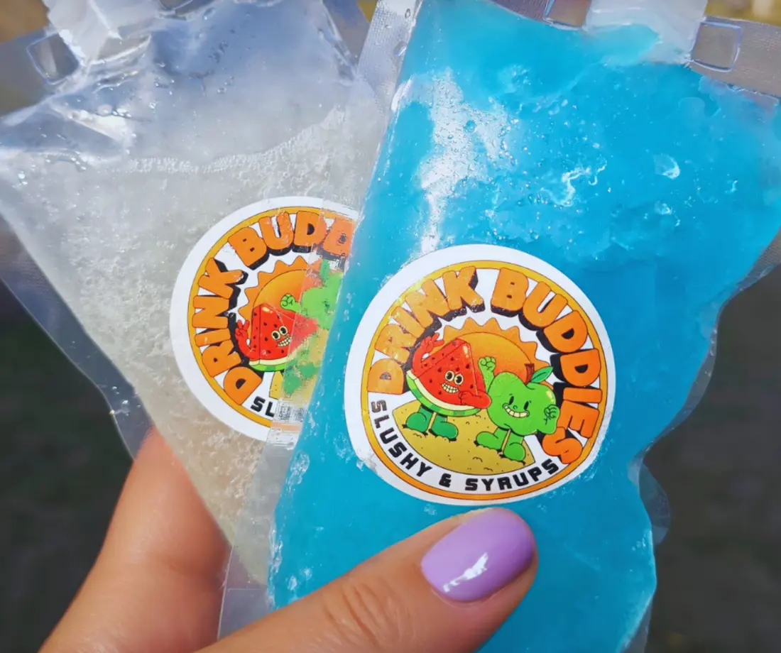 Two colourful DrinkBuddies frozen pouches held outdoors